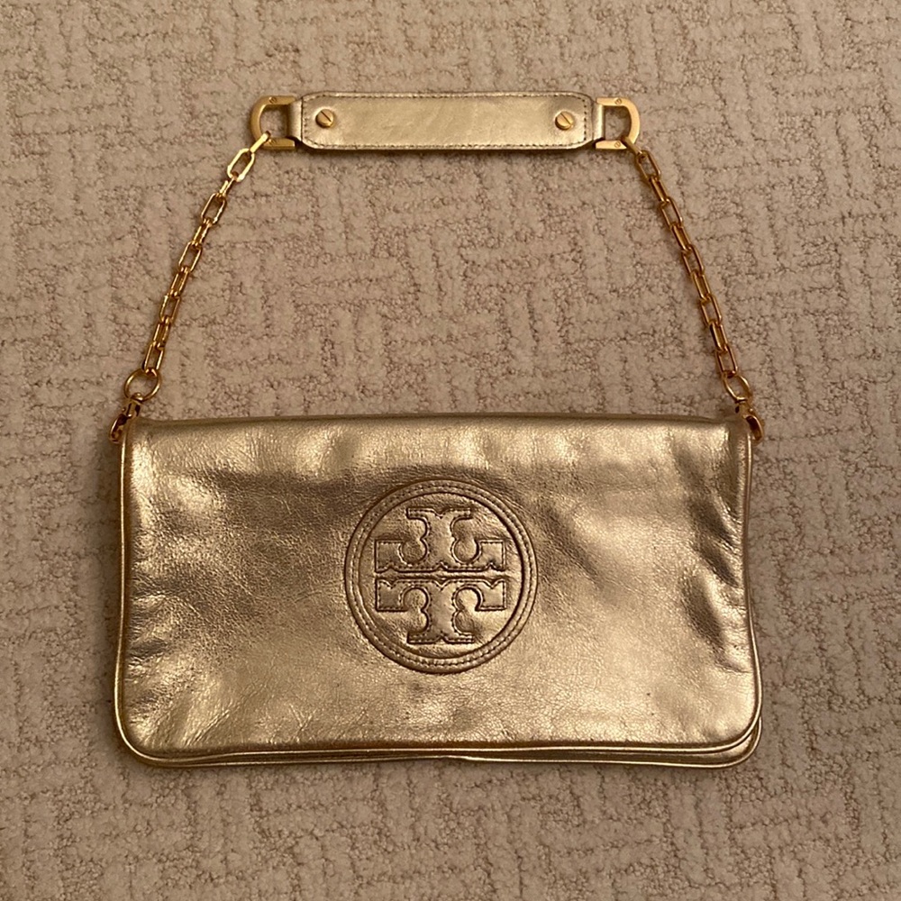 Tory Burch gold clutch with removable chain strap.